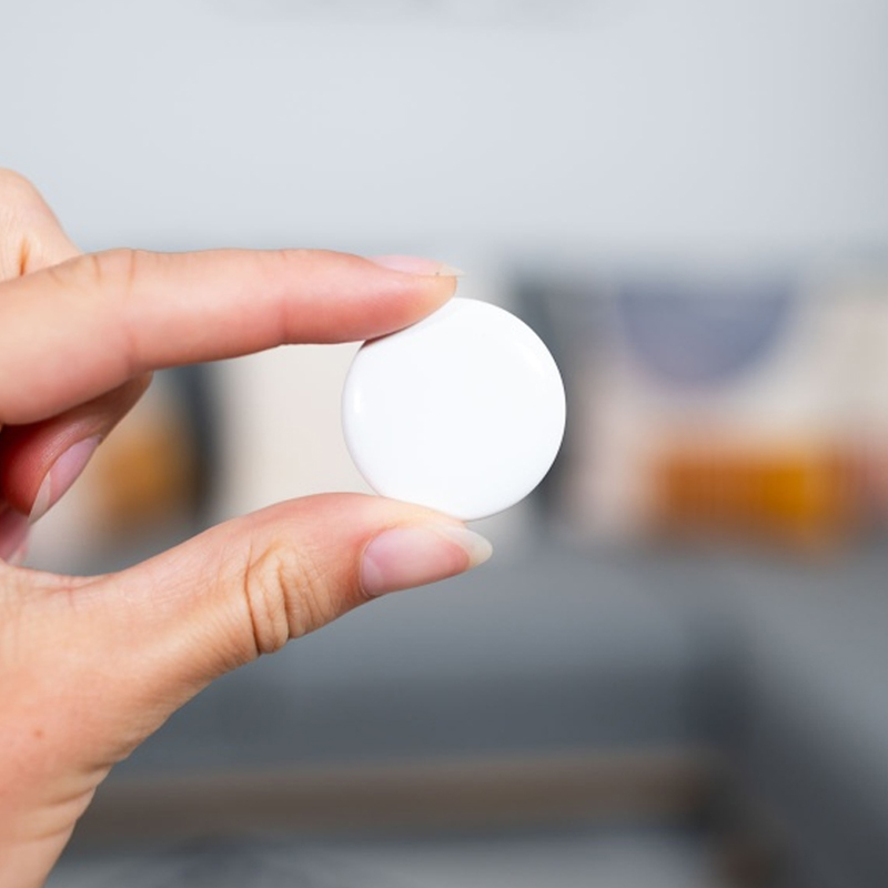 Person holding up an access control RFID coin tag