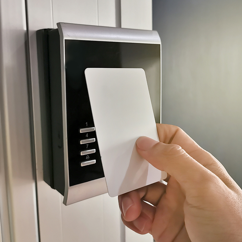 Person using access control key card on card reader to open door